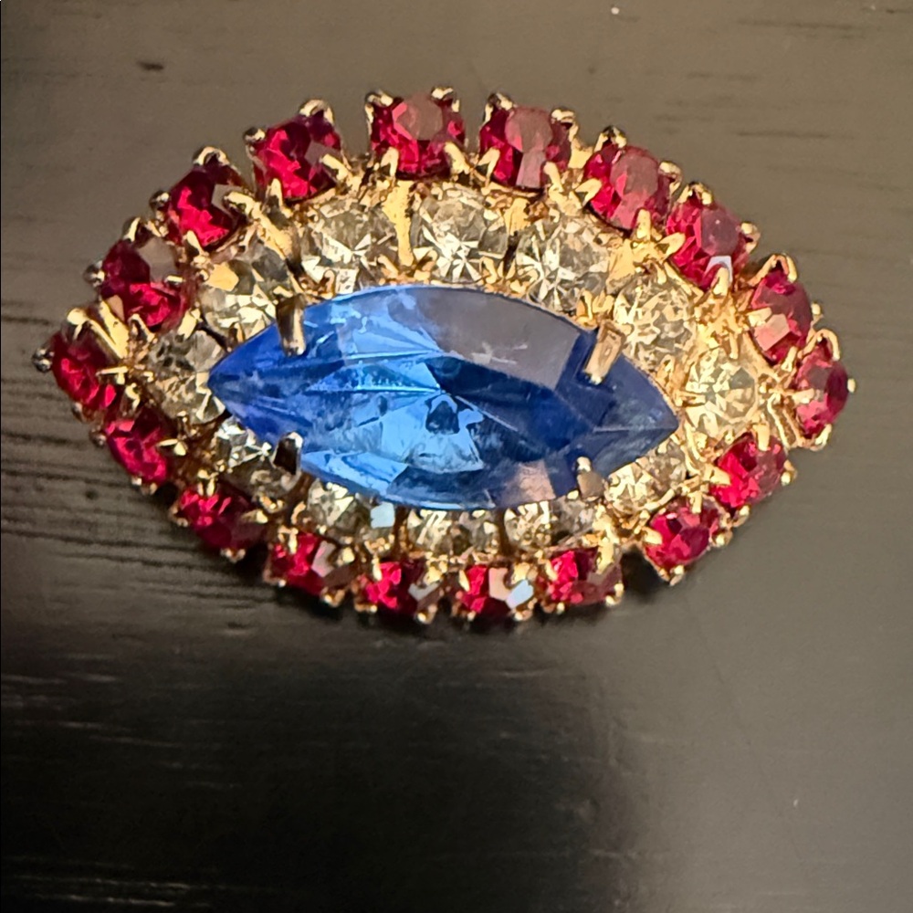 vintage cluster brooch featuring a prominent blue center stone